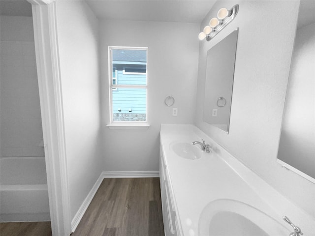 bathroom featuring wood-type flooring, vanity, and a bathtub