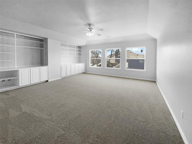 unfurnished living room featuring ceiling fan, built in features, carpet, and a textured ceiling