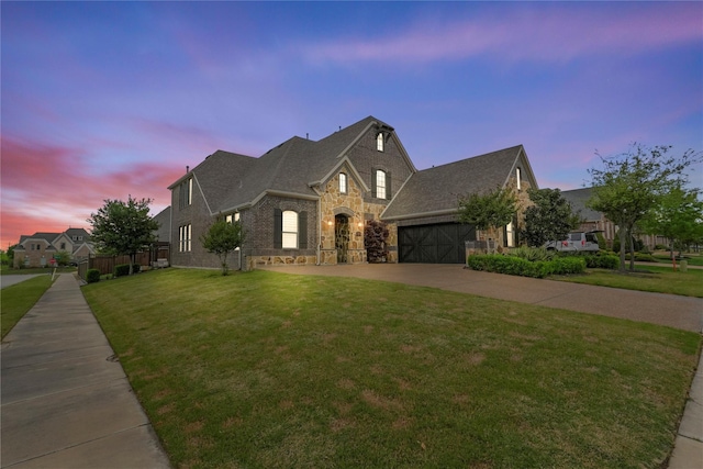 view of front of house with a garage and a lawn