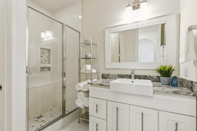 bathroom with a shower with door and vanity