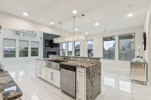 kitchen with dark stone counters, a sink, visible vents, white cabinets, and dishwasher