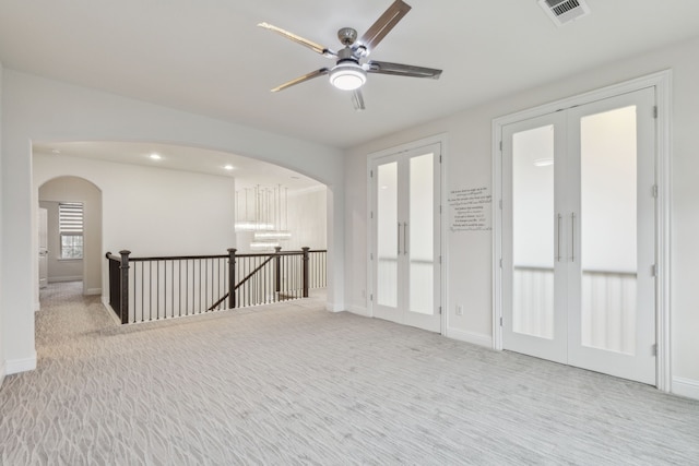 carpeted spare room with french doors and ceiling fan