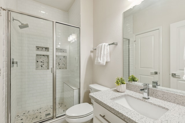 bathroom featuring walk in shower, vanity, and toilet