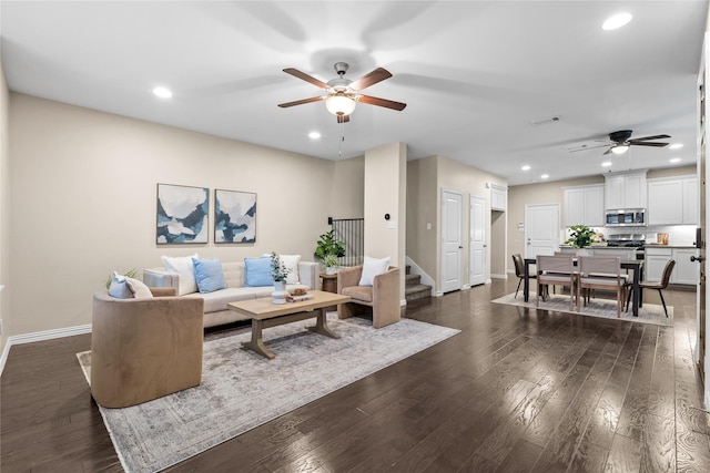 living room featuring dark wood-type flooring and ceiling fan