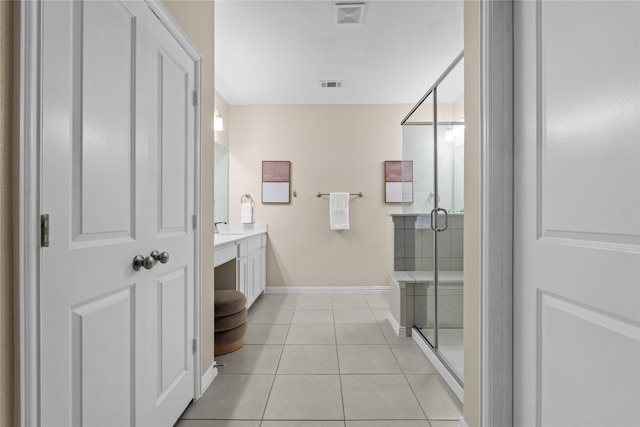 bathroom with tile patterned flooring, vanity, and a shower with shower door