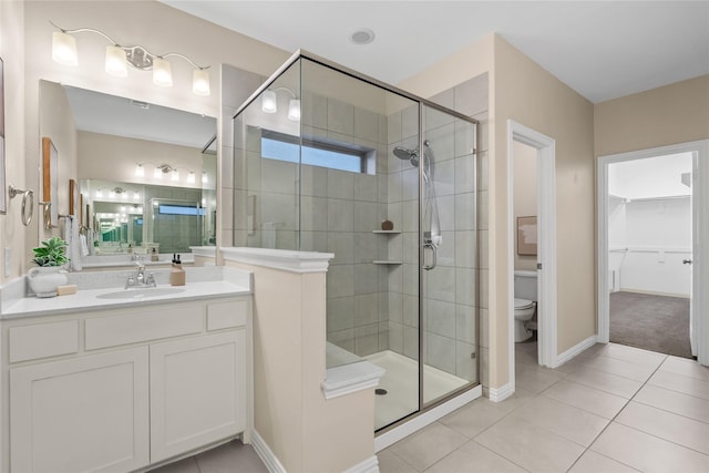 bathroom with an enclosed shower, vanity, tile patterned floors, and toilet