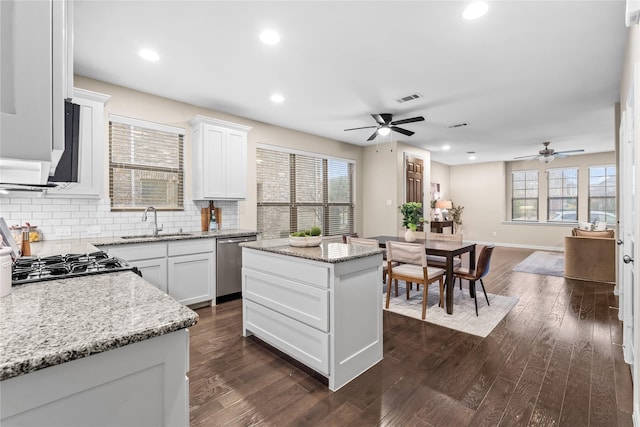 kitchen with white cabinetry, sink, stove, a center island, and stainless steel dishwasher