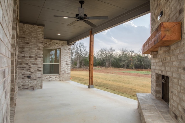 view of patio featuring an outdoor brick fireplace and a ceiling fan