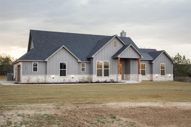 modern farmhouse featuring roof with shingles, board and batten siding, a chimney, and a front yard