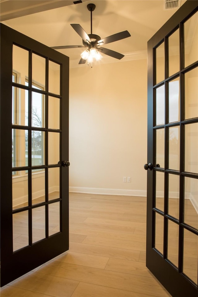 unfurnished room featuring light wood-style flooring, baseboards, ceiling fan, and french doors