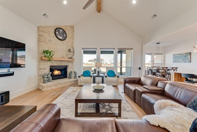 living room with high vaulted ceiling, light wood-type flooring, beamed ceiling, ceiling fan, and a fireplace