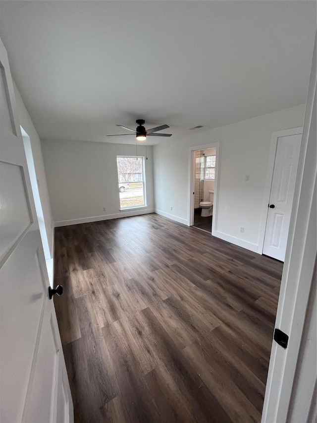 interior space with dark wood-type flooring and ceiling fan