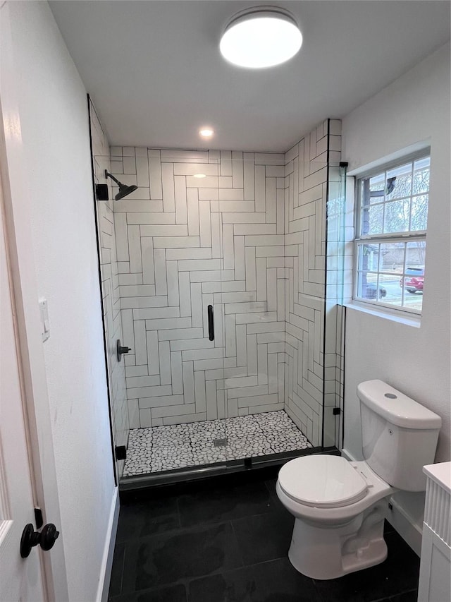 bathroom featuring vanity, toilet, and a shower with shower door