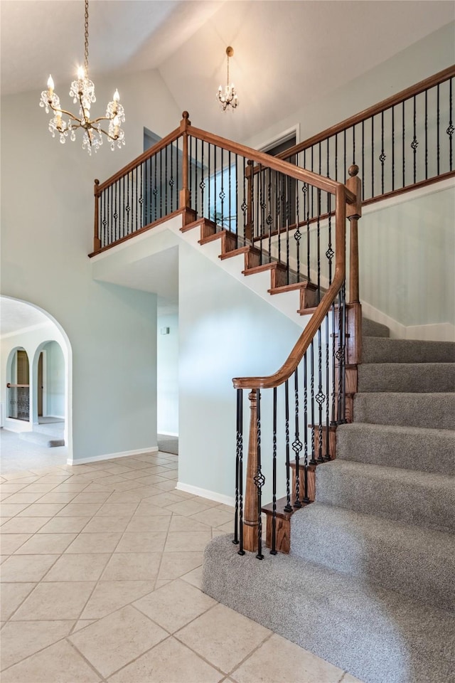 stairway featuring an inviting chandelier, tile patterned flooring, and high vaulted ceiling