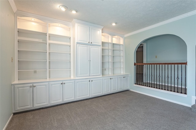 unfurnished room featuring ornamental molding, carpet, and a textured ceiling