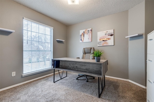 home office featuring a textured ceiling, carpet, and baseboards