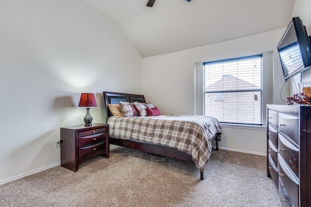 bedroom featuring light colored carpet, vaulted ceiling, baseboards, and ceiling fan