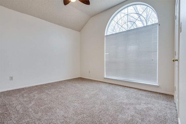 empty room with lofted ceiling, carpet flooring, ceiling fan, and a textured ceiling