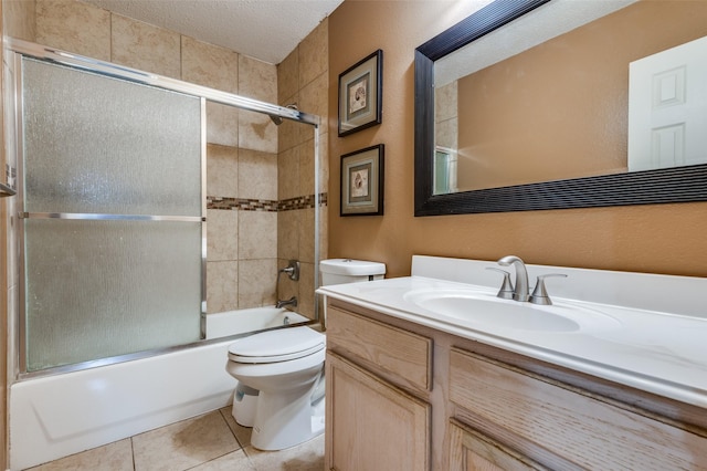 full bathroom featuring toilet, tile patterned floors, combined bath / shower with glass door, a textured ceiling, and vanity