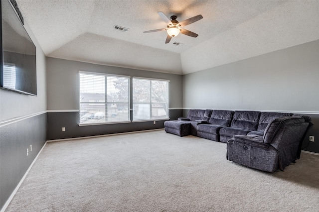 living room with visible vents, a ceiling fan, lofted ceiling, a textured ceiling, and carpet flooring