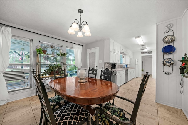 dining space with an inviting chandelier, sink, and light tile patterned flooring