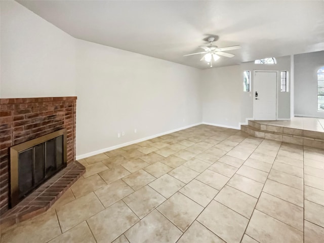 unfurnished living room featuring ceiling fan, light tile patterned floors, and a fireplace