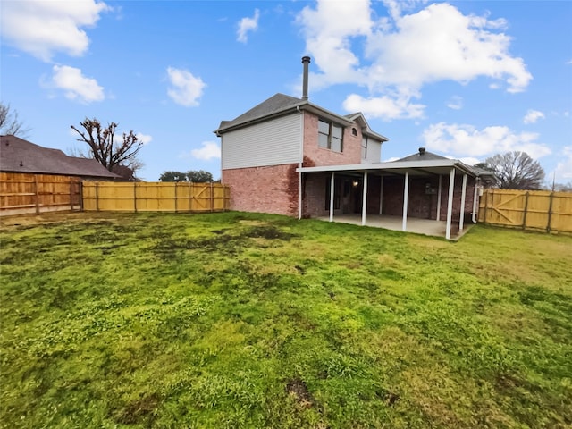 rear view of property with a yard and a patio area