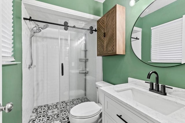 bathroom with vanity, a shower with shower door, and toilet