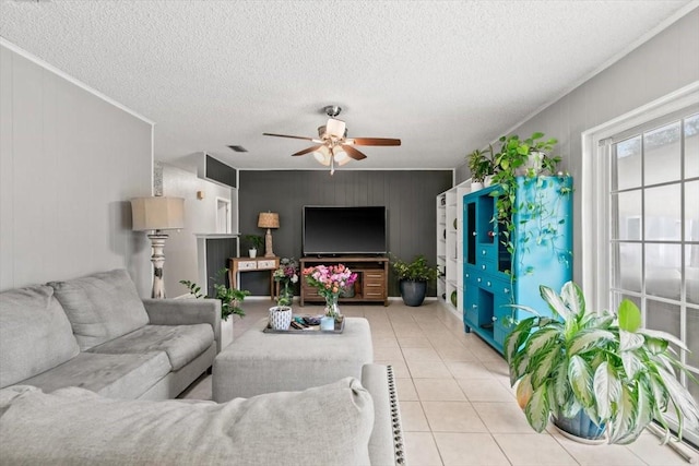 tiled living room with crown molding, a textured ceiling, and ceiling fan