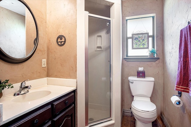 bathroom with vanity, a shower with shower door, and toilet