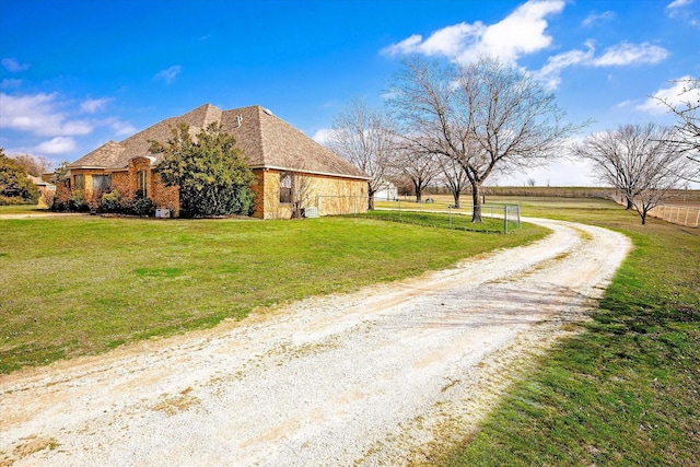 view of side of property with a yard and a rural view