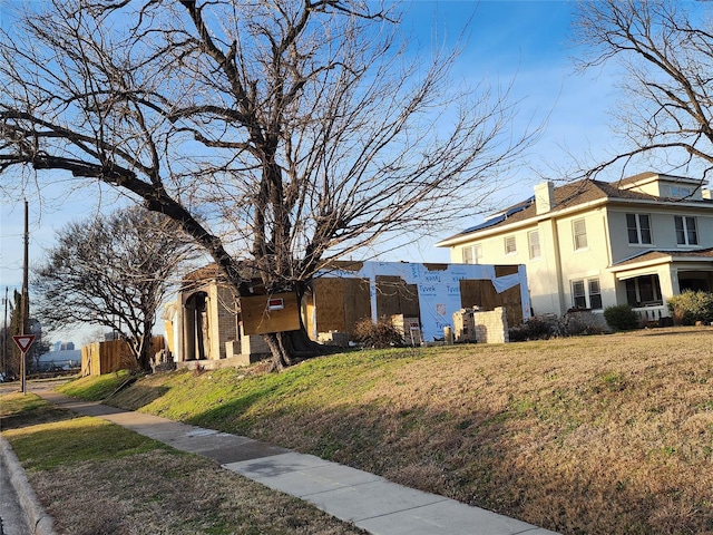 view of side of home with a yard