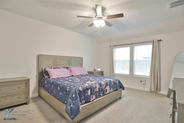 carpeted bedroom with ceiling fan and vaulted ceiling