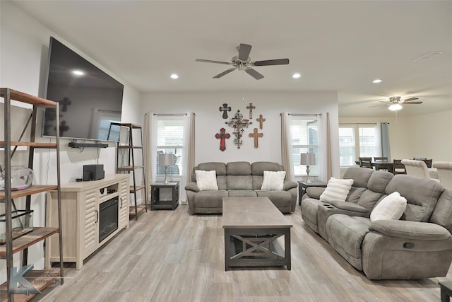 living room featuring light hardwood / wood-style flooring and ceiling fan