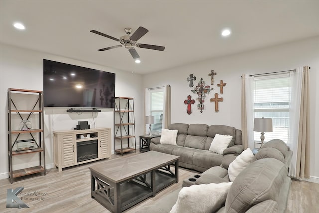 living room featuring ceiling fan and light hardwood / wood-style flooring