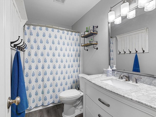 bathroom with wood-type flooring, toilet, and vanity