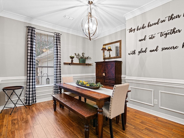 dining room featuring an inviting chandelier, hardwood / wood-style floors, and crown molding