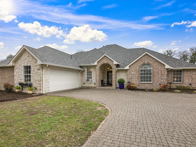 ranch-style house featuring a garage and a front lawn