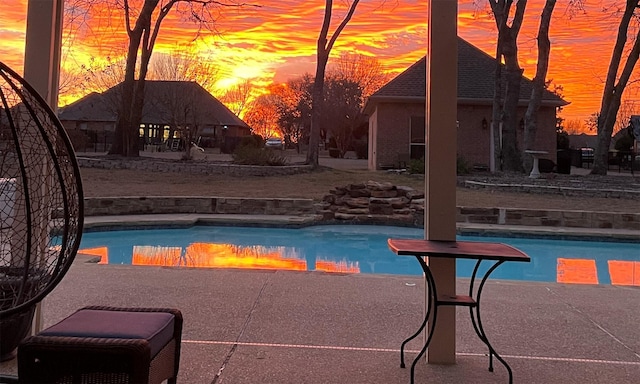 pool at dusk with a patio