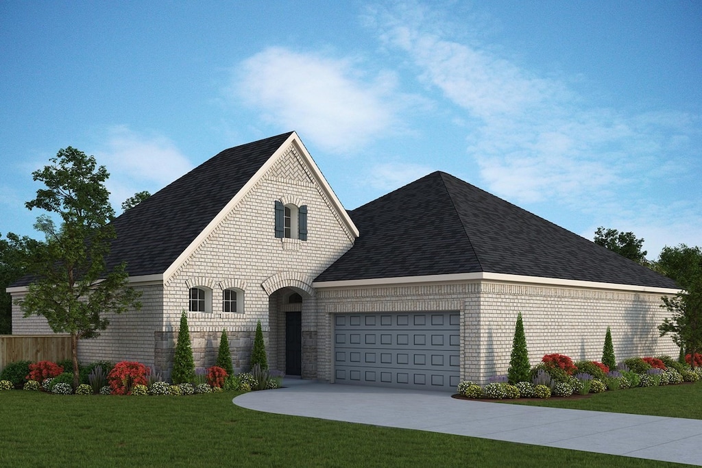 french provincial home featuring a garage and a front yard