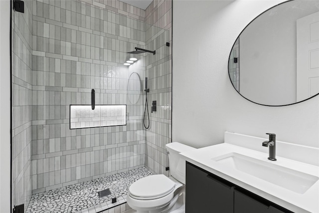 bathroom with vanity, a shower with shower door, and toilet