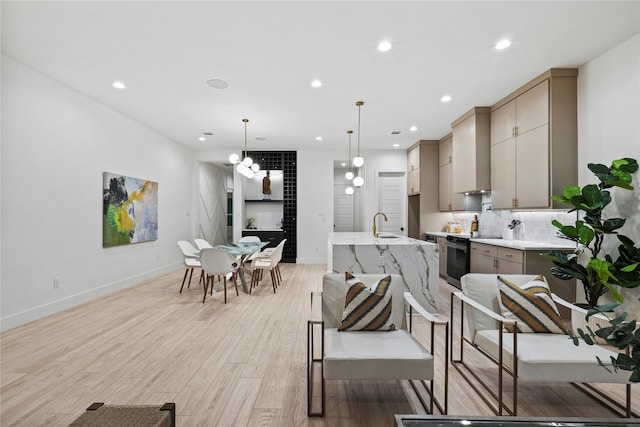 kitchen with electric range oven, decorative light fixtures, tasteful backsplash, gray cabinetry, and light wood-type flooring