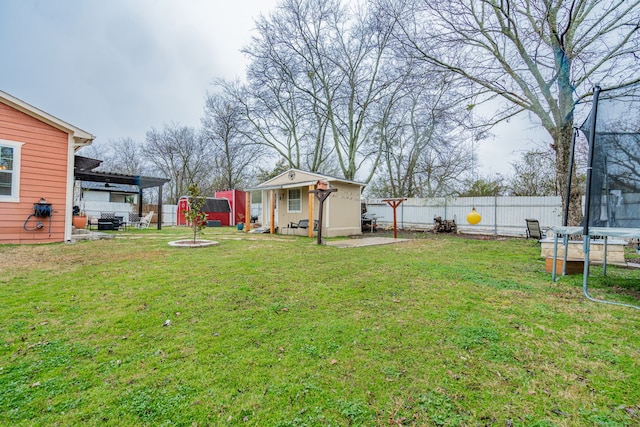 view of yard featuring an outbuilding and a trampoline