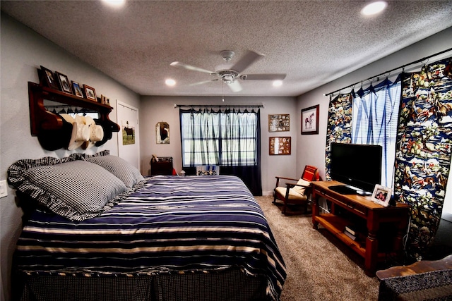 bedroom with ceiling fan, carpet floors, and a textured ceiling