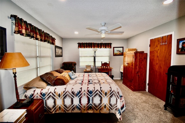 bedroom with ceiling fan, light carpet, and a textured ceiling