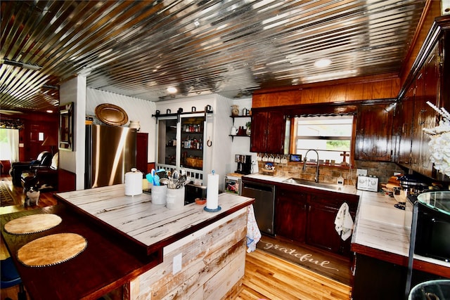 kitchen with stainless steel appliances, light hardwood / wood-style floors, and sink