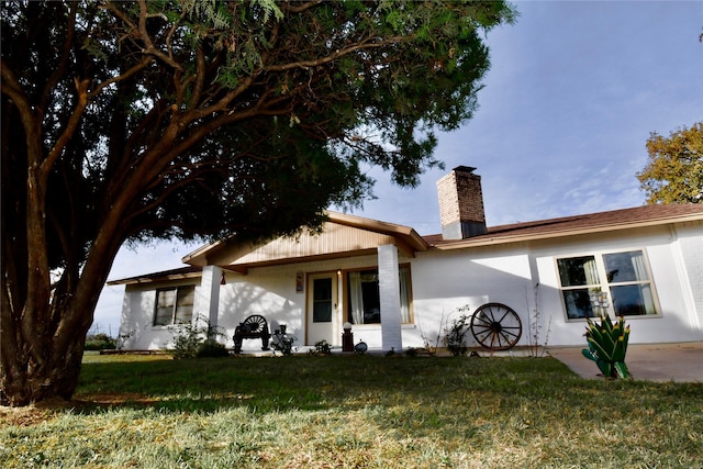 rear view of house featuring a lawn