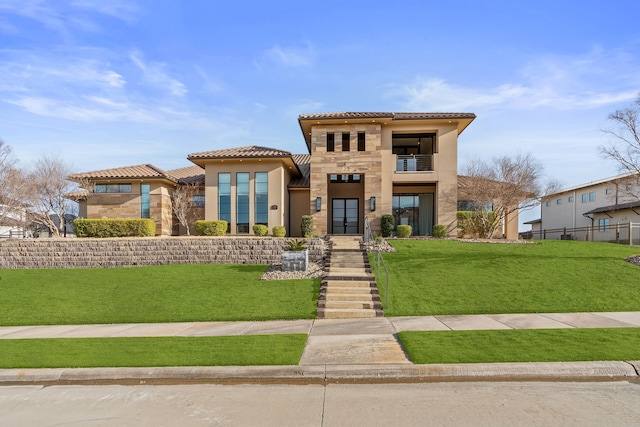 mediterranean / spanish-style home with a front yard and a balcony