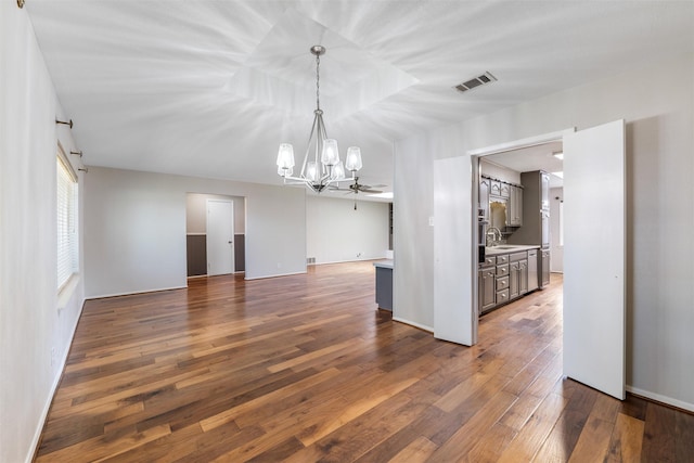 interior space with dark wood-type flooring, visible vents, a sink, and ceiling fan with notable chandelier