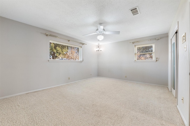 unfurnished room with a textured ceiling, ceiling fan, visible vents, and light colored carpet